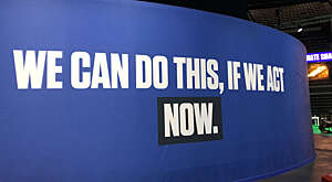 Standing billboard at COP26 event centre saying: "We can do this, if we act now".